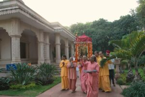 Monks carry the palanquin around ashram grounds.