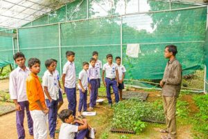 Volunteer talks to boys on basics of Organic gardening.
