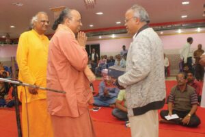 Swamiji presents Guruji’s books to a senior editor of local newspaper.