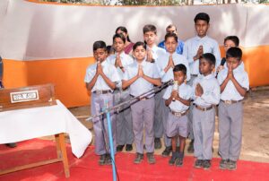 स्कूल के बच्चे सार्वजनिक संबोधन से पहले प्रार्थना करते हुए।