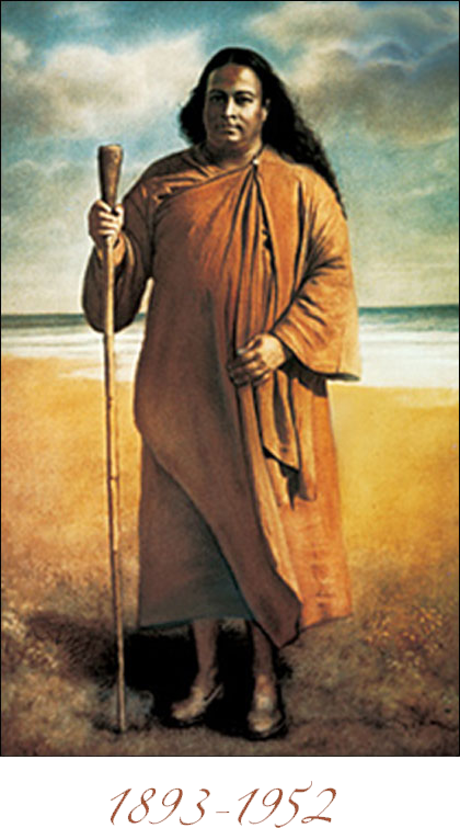 Paramahansa Yogananda standing on a seashore with his stick