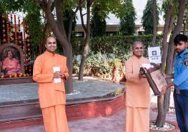 Swami Smaranananda distributes gifts to the staff.