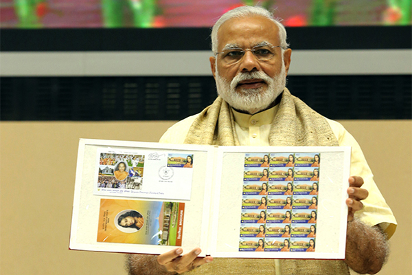 Sri Narendra Modi displays the commemorative stamp.
